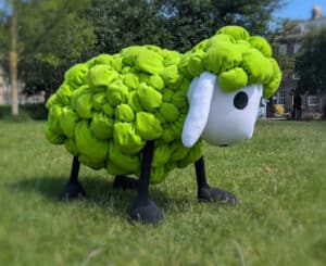 A giant soft sculpture of a green sheep by Picture to Puppet