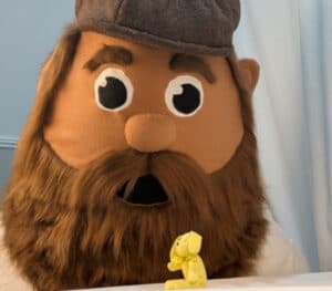 A custom mascot costume made in the UK looking at a miniature custom made toy